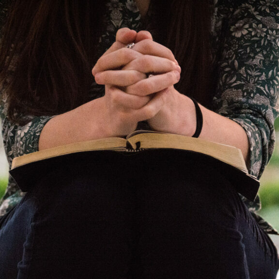 person-sitting-while-reading-book-and-praying